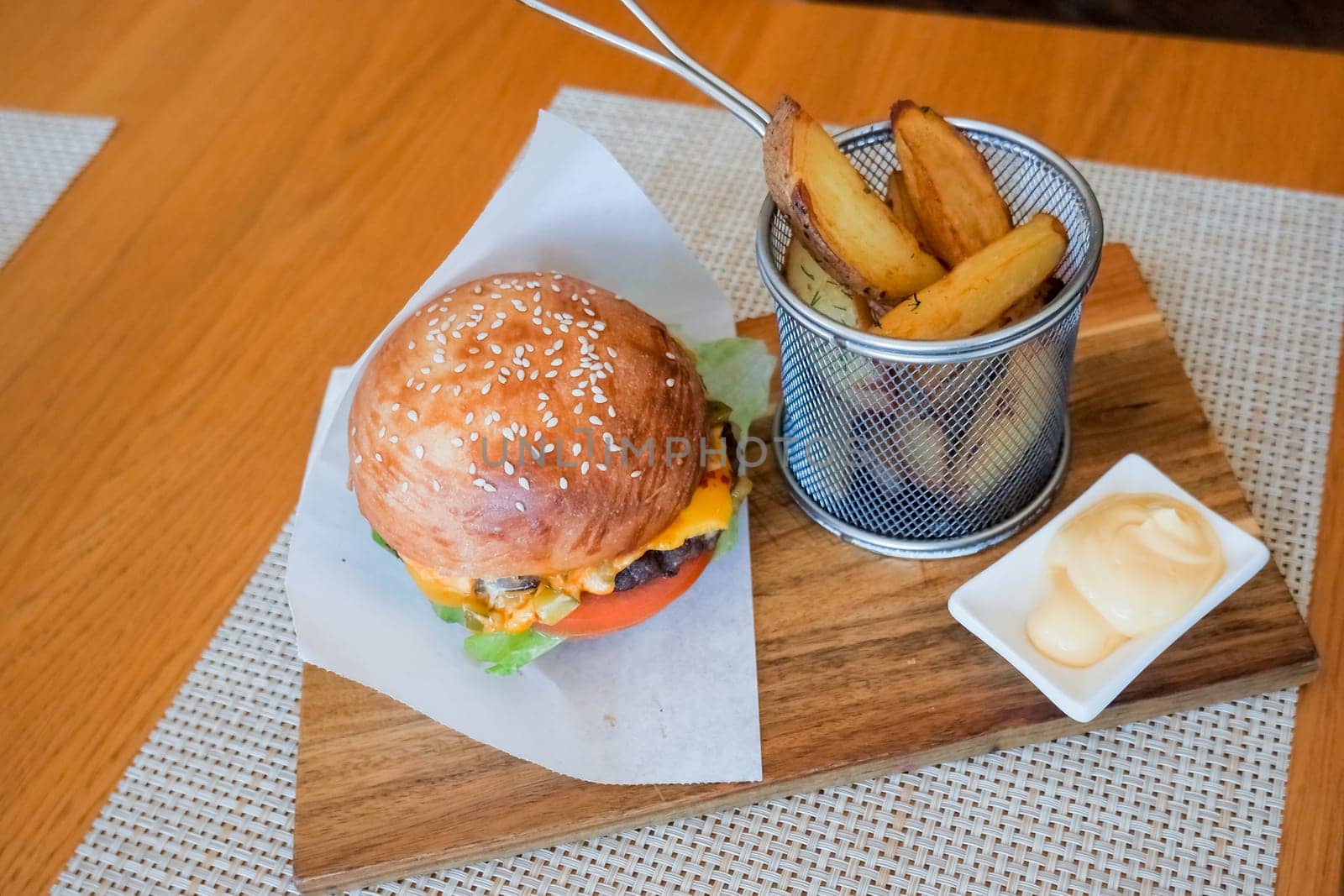 Hamburger with fries and sauce.fast food and unhealthy eating concept - close up of fast food snacks on wooden table.