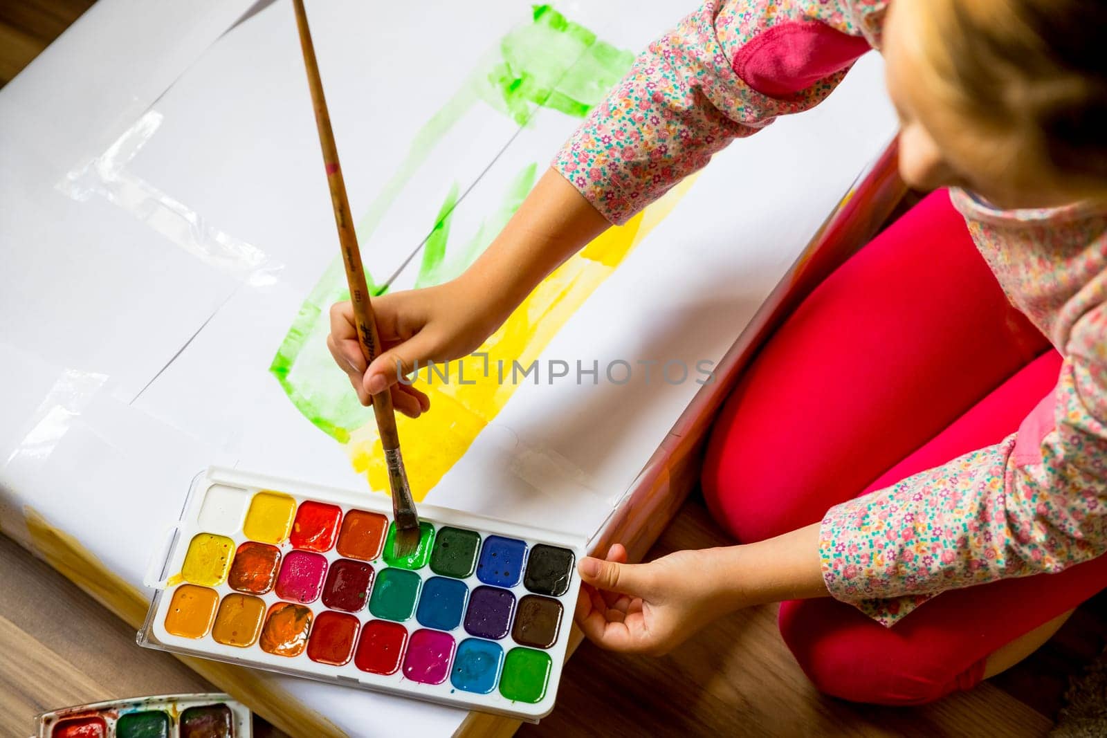 Little girl painting in her nursery at home