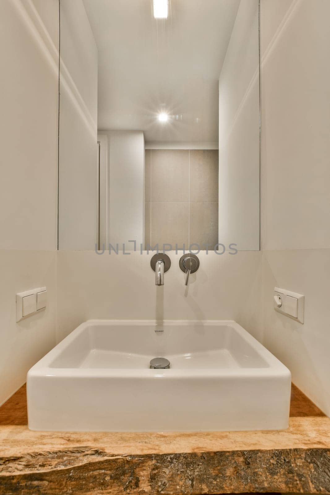 a large white sink in a bathroom with a mirror by casamedia