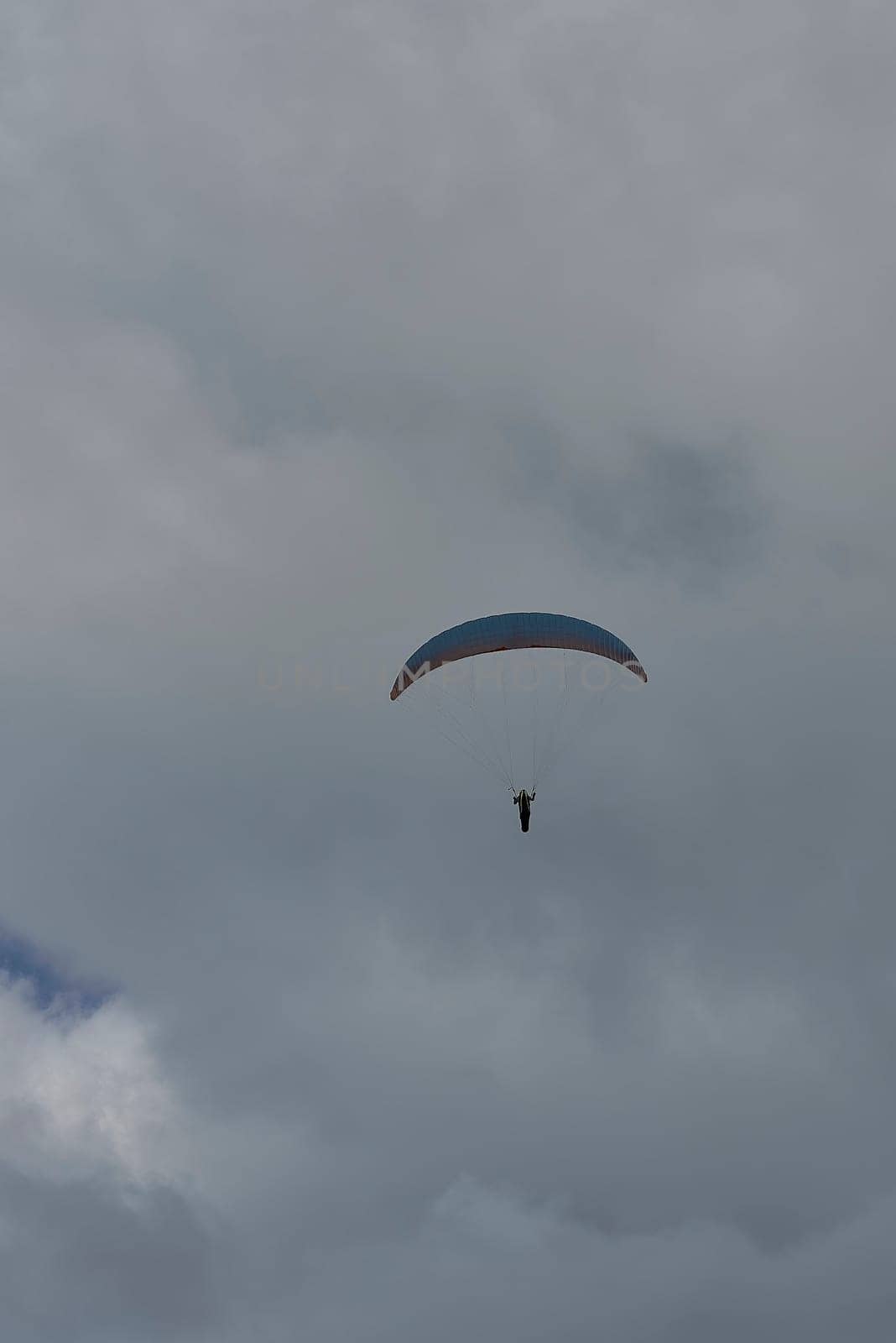 A person paragliding on a cloudy day by raul_ruiz