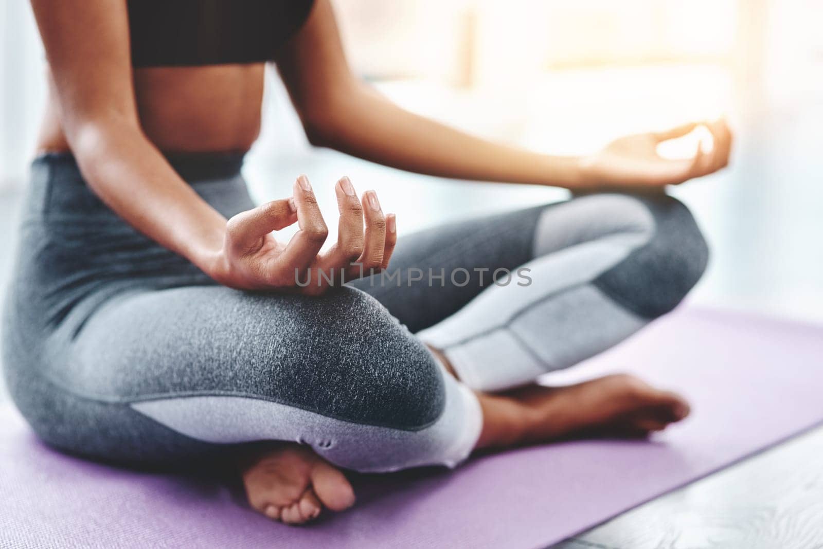 Nothing is as calming as a yoga session. an unrecognizable woman practising yoga