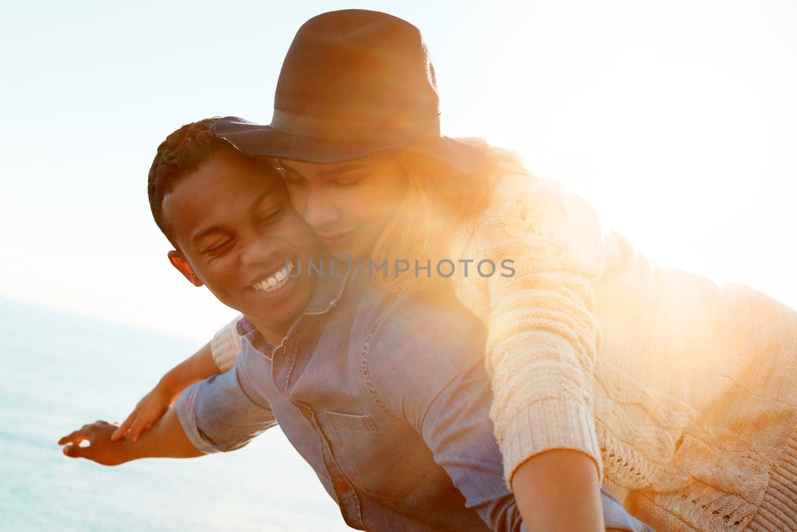 Surrender to the beauty of love. a happy young couple enjoying a piggyback ride outdoors. by YuriArcurs