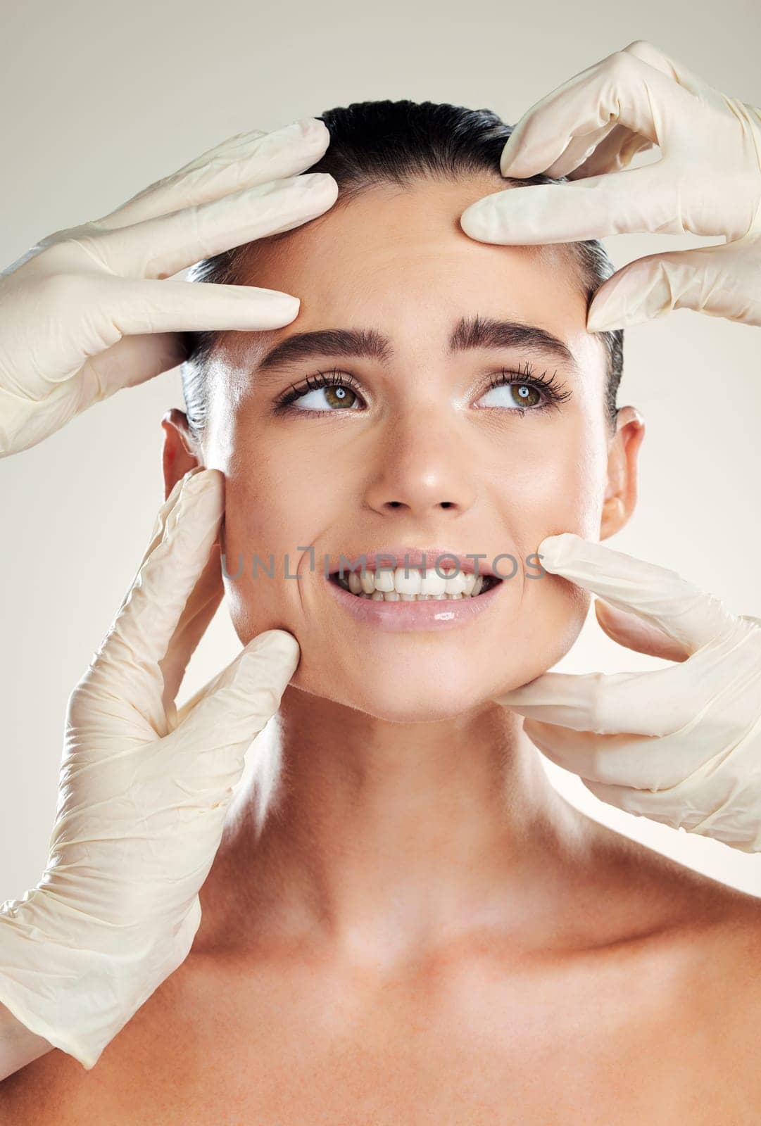 Beauty, plastic surgery and filler on face of woman with collagen dermatology cosmetics. Headshot of a skincare model with professional hands for medical procedure on facial skin and grey background by YuriArcurs