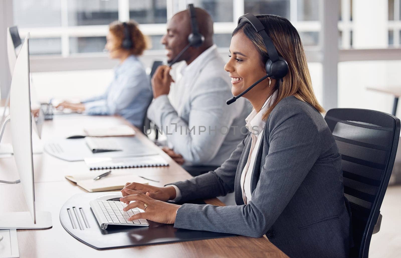 Call center woman, computer and typing with smile, reading and customer support with happiness at job. Indian telemarketing consultant, desktop pc and happy crm with communication in modern office by YuriArcurs