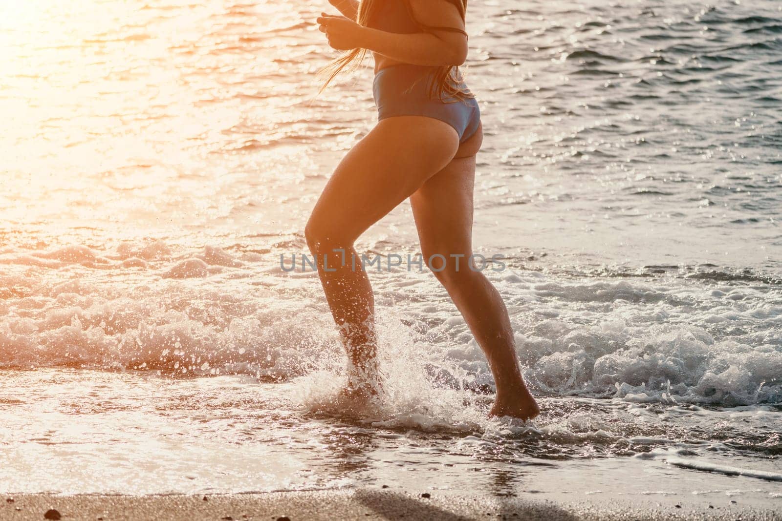 Running woman on a summer beach. A woman jogging on the beach at sunrise, with the soft light of the morning sun illuminating the sand and sea, evoking a sense of renewal, energy and health. by panophotograph