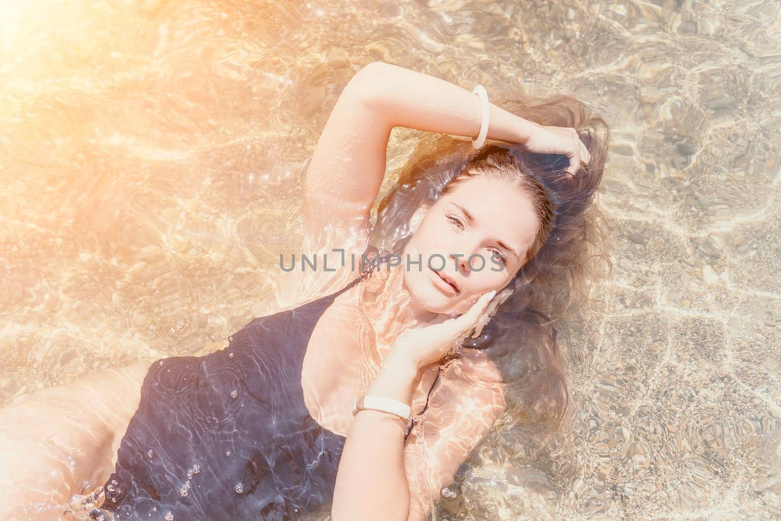 Woman travel sea. Young Happy woman in a long red dress posing on a beach near the sea on background of volcanic rocks, like in Iceland, sharing travel adventure journey