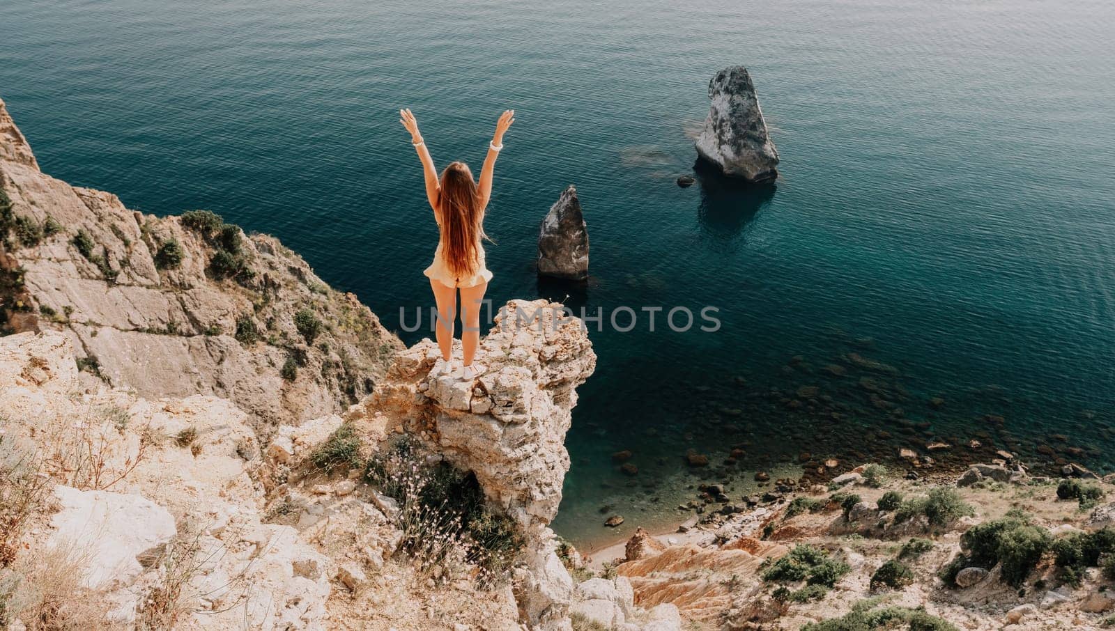 Woman travel sea. Happy tourist enjoy taking picture outdoors for memories. Woman traveler looks at the edge of the cliff on the sea bay of mountains, sharing travel adventure journey by panophotograph