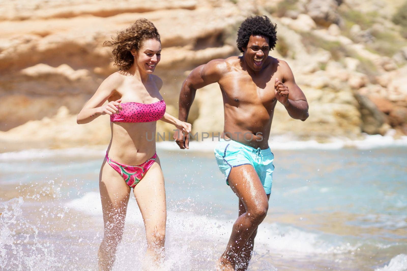 Happy diverse couple having fun in sea water by javiindy