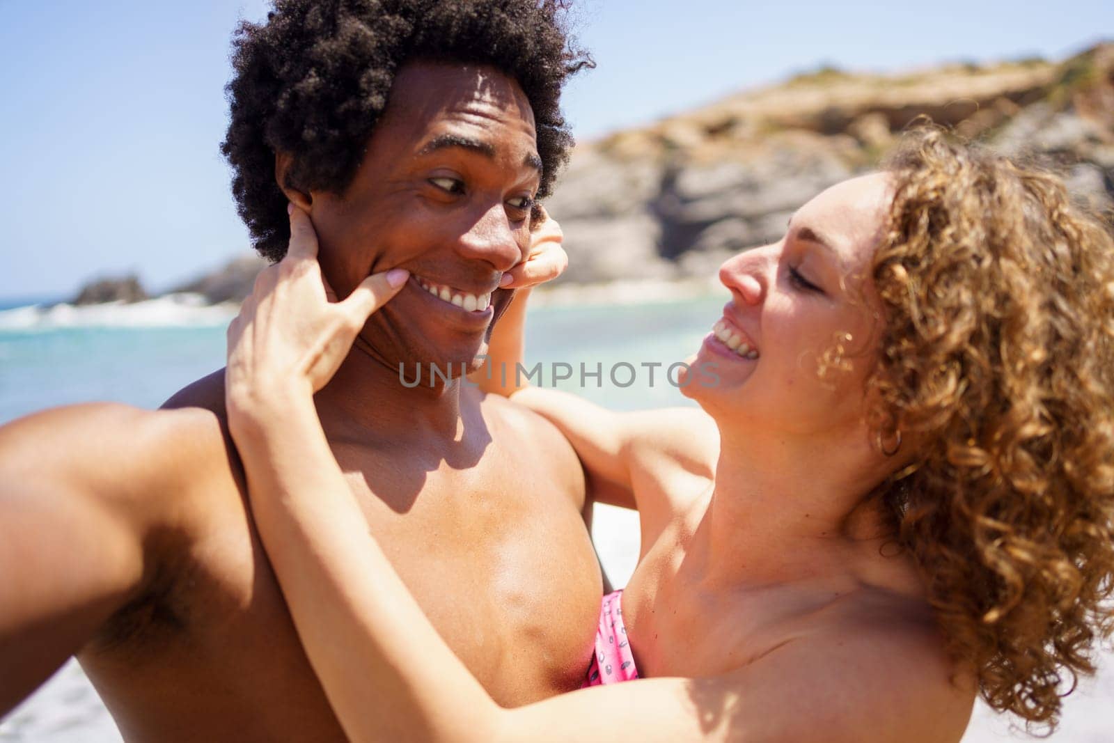 Selfie of cheerful woman stretching corners of boyfriends mouth by javiindy