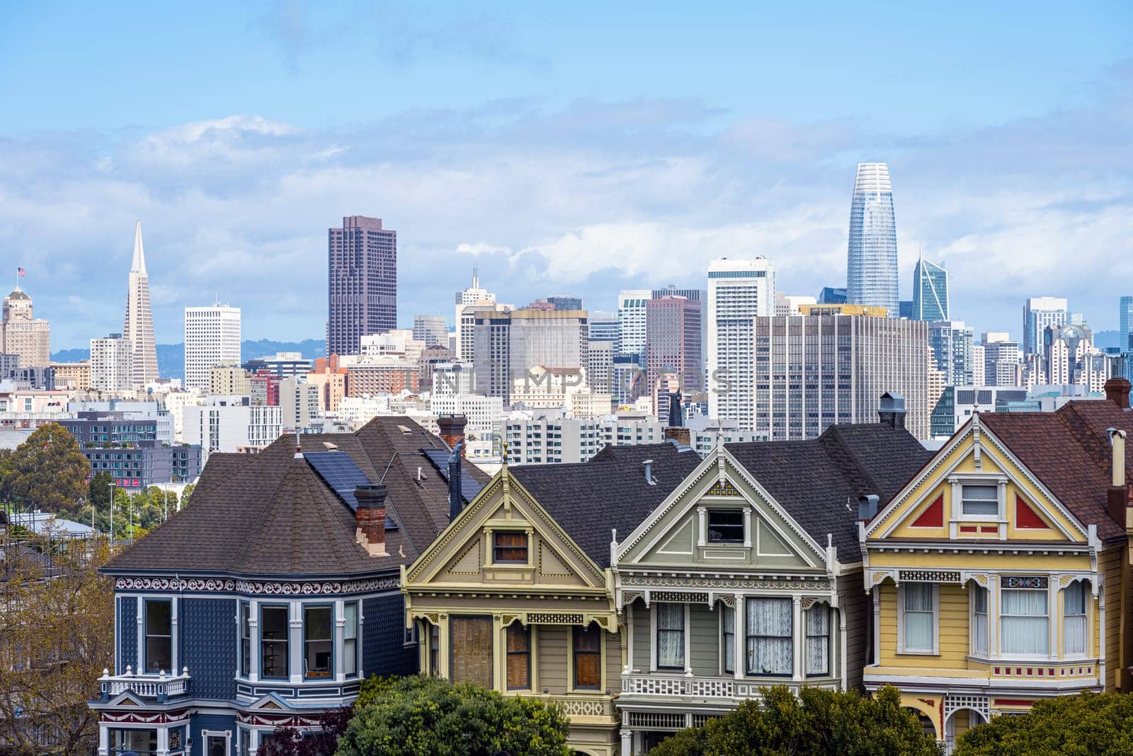 Old victorian houses in San Francisco with the downtown skyline in the back