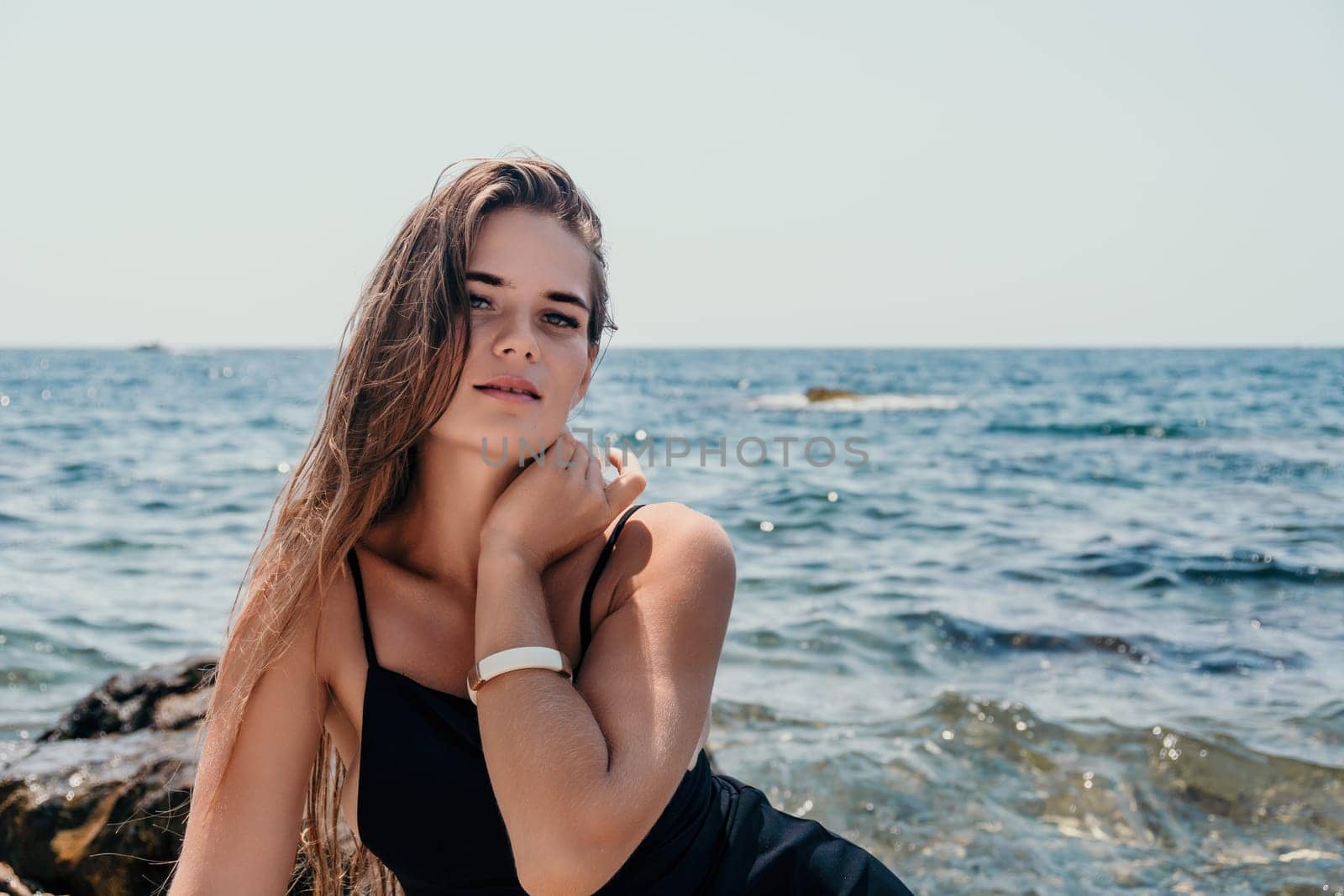 Woman summer travel sea. Happy tourist in hat enjoy taking picture outdoors for memories. Woman traveler posing on the beach at sea surrounded by volcanic mountains, sharing travel adventure journey by panophotograph