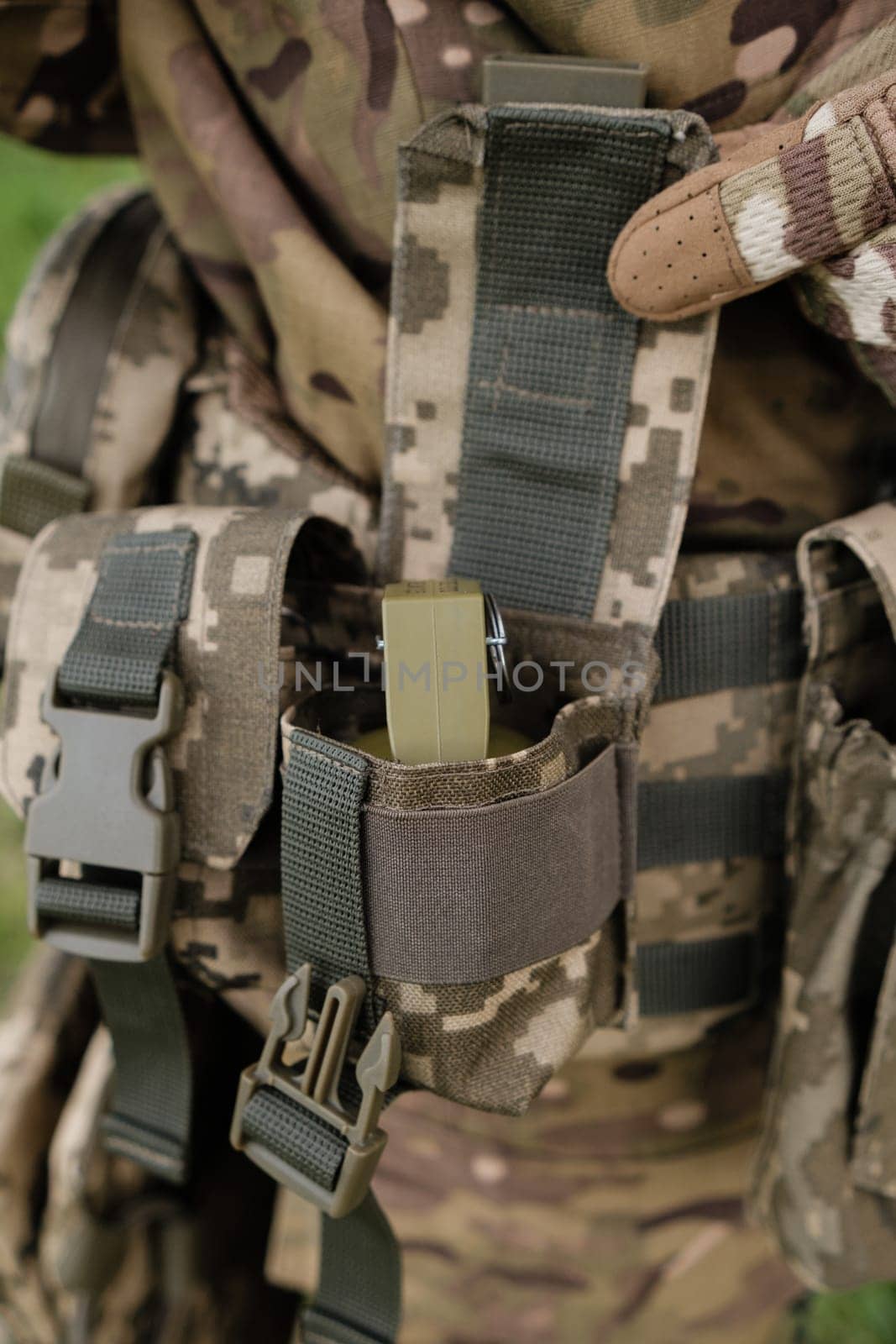 Preparing for Combat: Close-up of Soldier Putting on Gear in the Field before fight by Symonenko
