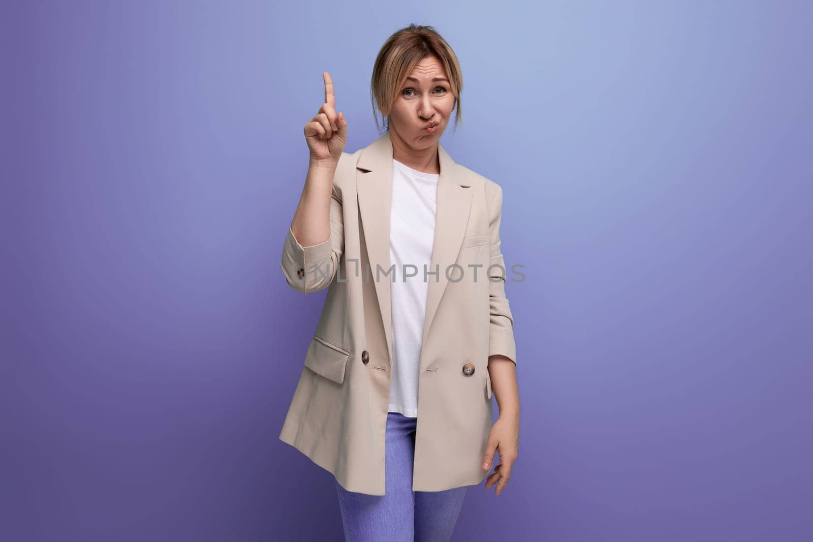 smart blond business young woman in jacket on studio background with copy space for advertising by TRMK