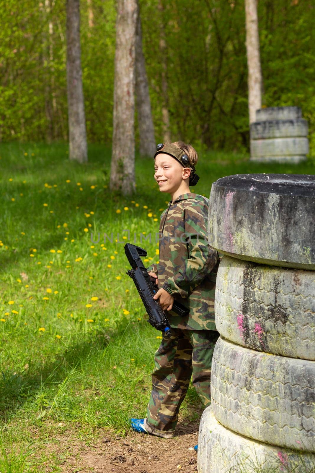 Boy weared in camouflage playing laser tag in special forest playground. by BY-_-BY