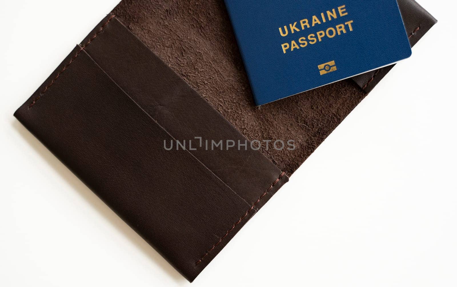 Ukrainian biometric passport id on a leather passport cover to travel the Europe without visas on the table. Inscription in Ukrainian Ukraine Passport