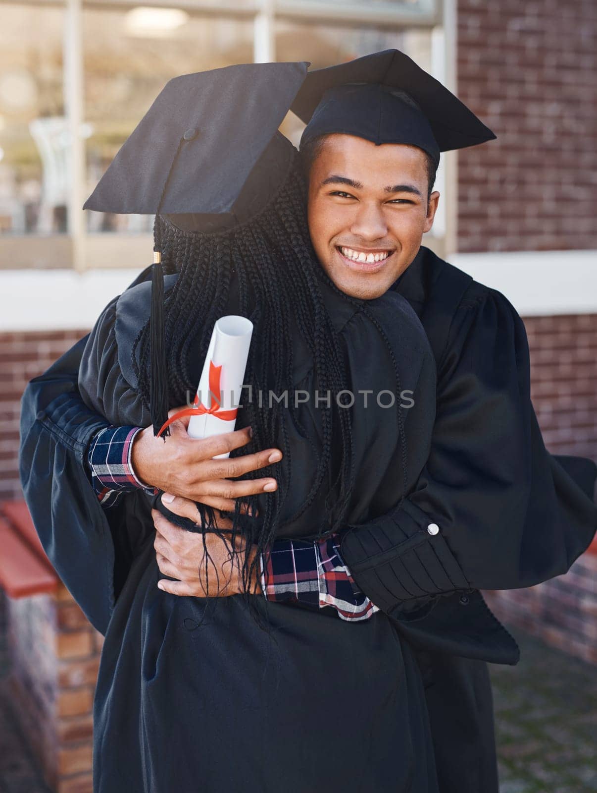 Things end but memories last forever. two happy young students hugging each other on graduation day. by YuriArcurs