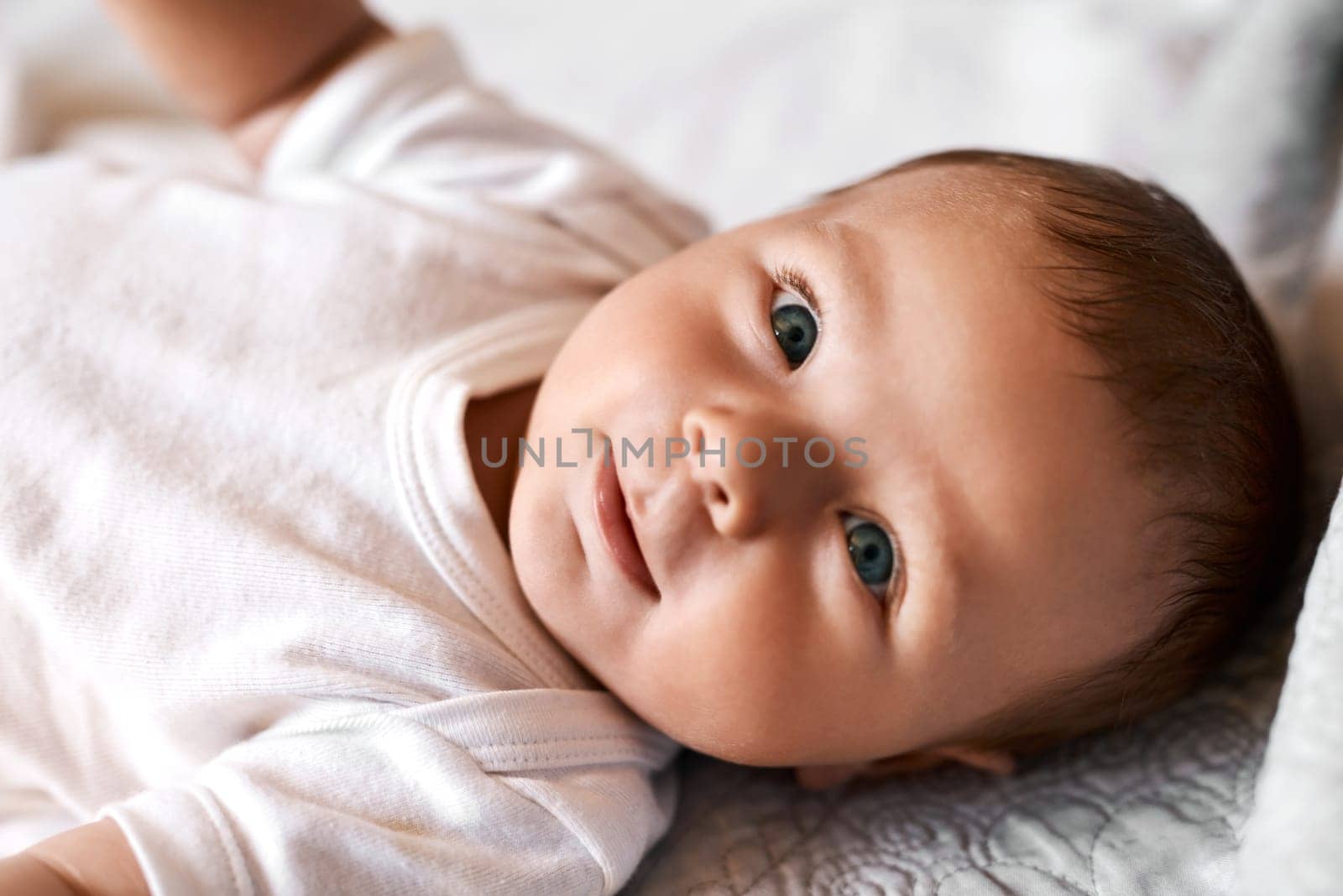 Meet Mr Adorable. an adorable baby boy lying down on a bed at home. by YuriArcurs