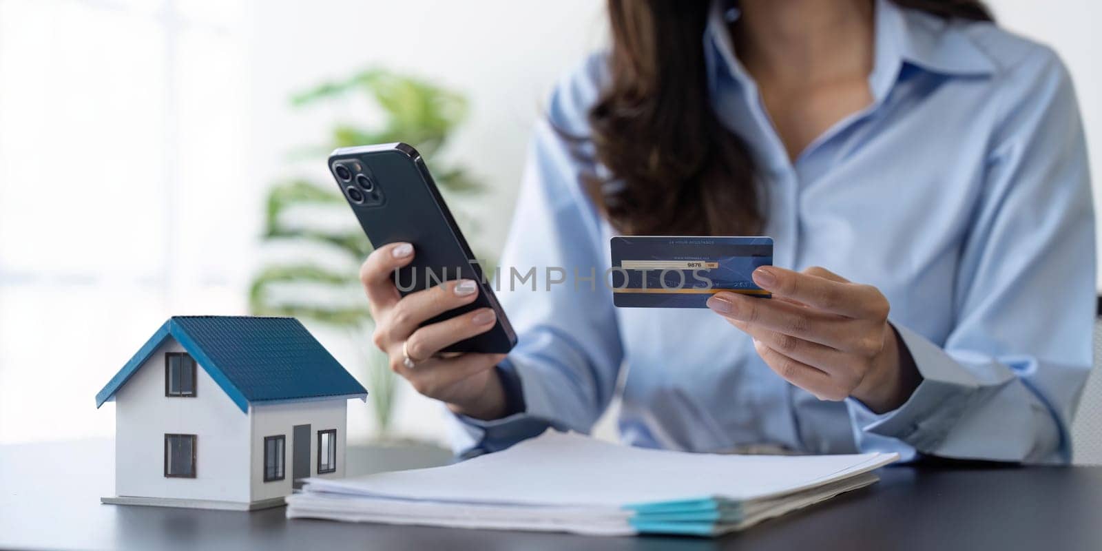 Woman holding credit card and using mobile phone. Online payment, Internet banking, Shopping online.