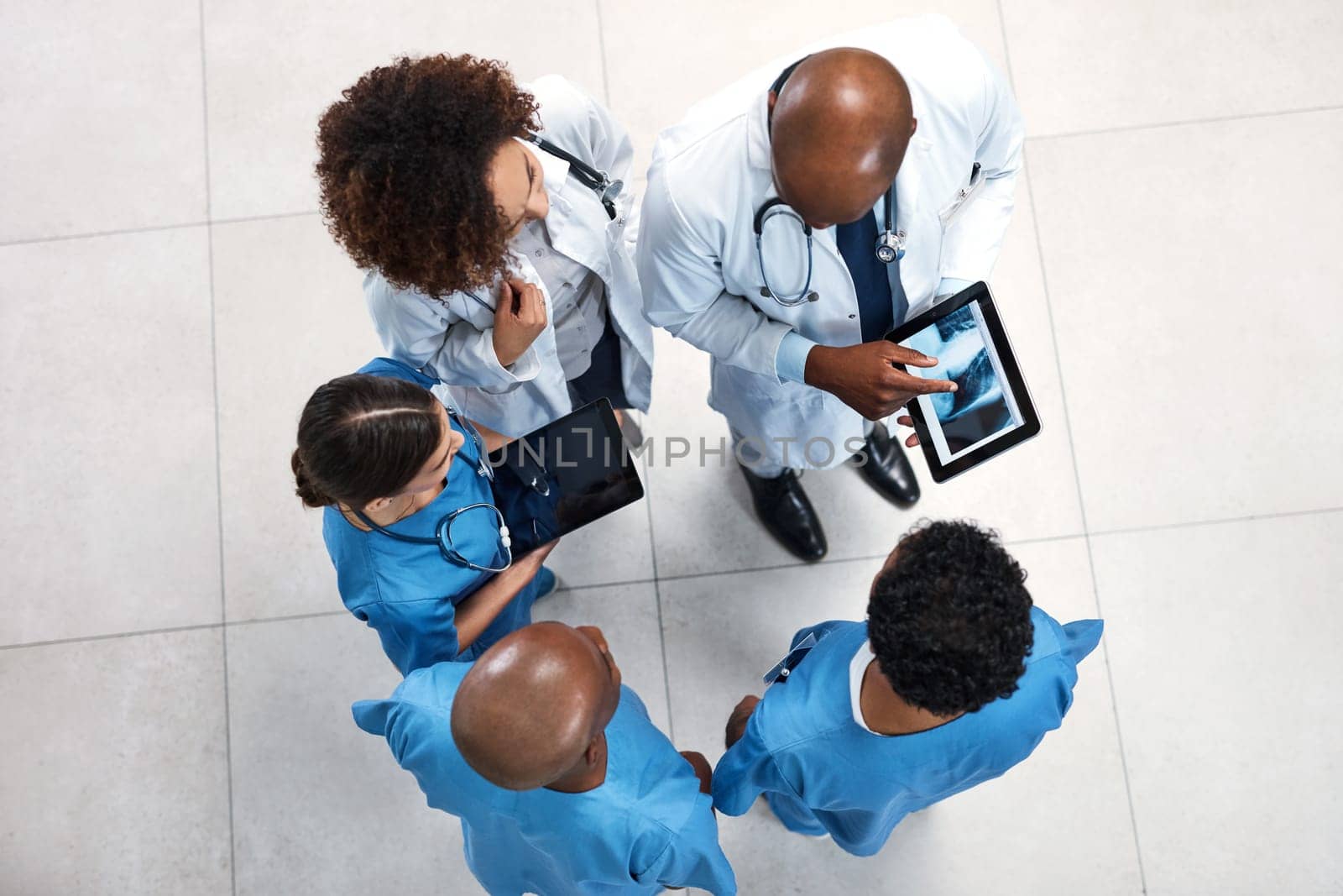 Taking a deeper look into the diagnosis. High angle shot of a medical practitioners looking at x-ray scans on a digital tablet in a hospital