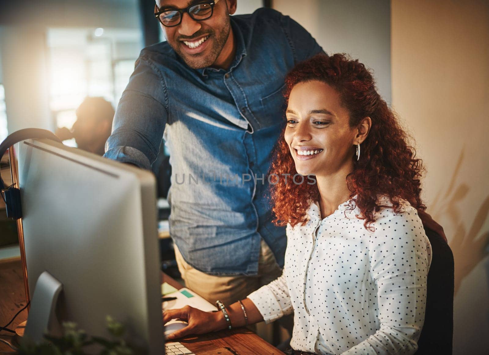 They welcome a little overnight work. a young businessman and businesswoman using a computer together during a late night at work