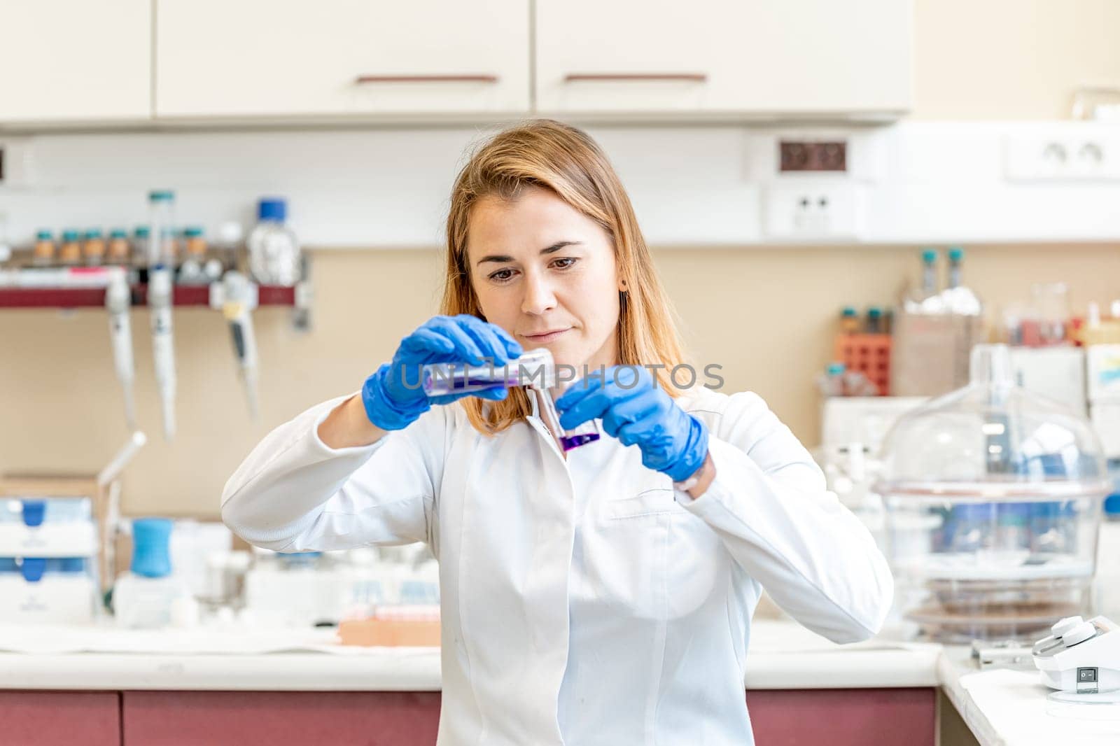 young attractive female scientist examines chemical samples of substances and drugs in a research laboratory. High quality photo