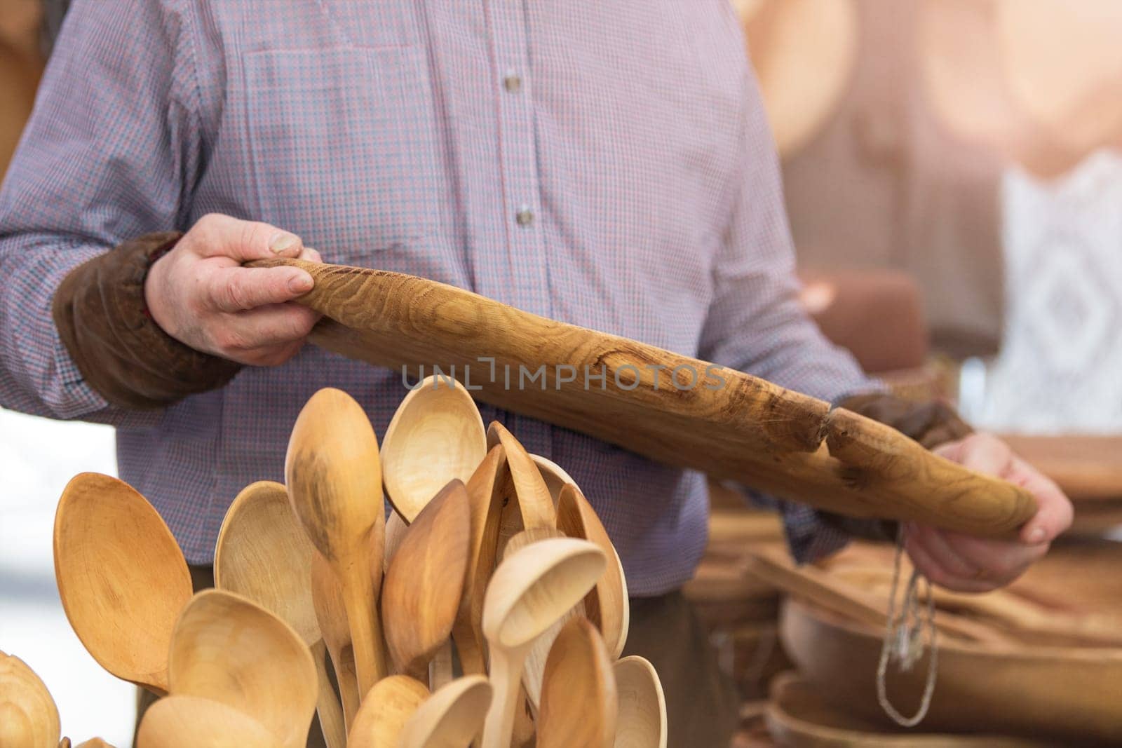 Production of wooden products in the concept of small business. Carpenter holding a rare wood tray in a carpentry workshop. Manufacture and sale of wooden furniture. High quality photo