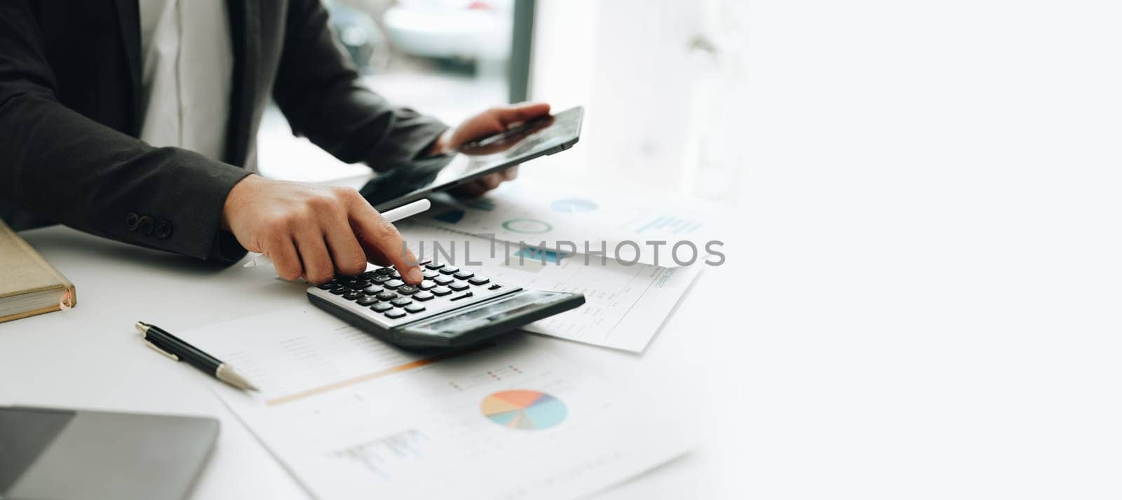 Young asian male work with financial papers at home count on calculator before paying taxes receipts online, planning budget glad to find chance for economy saving money, audit concepts. by Manastrong