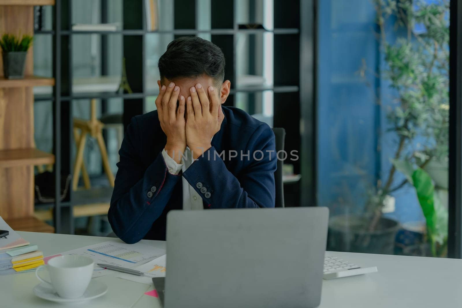 Portrait of business owner, man using computer and financial statements Anxious expression on expanding the market to increase the ability to invest in business. by Manastrong