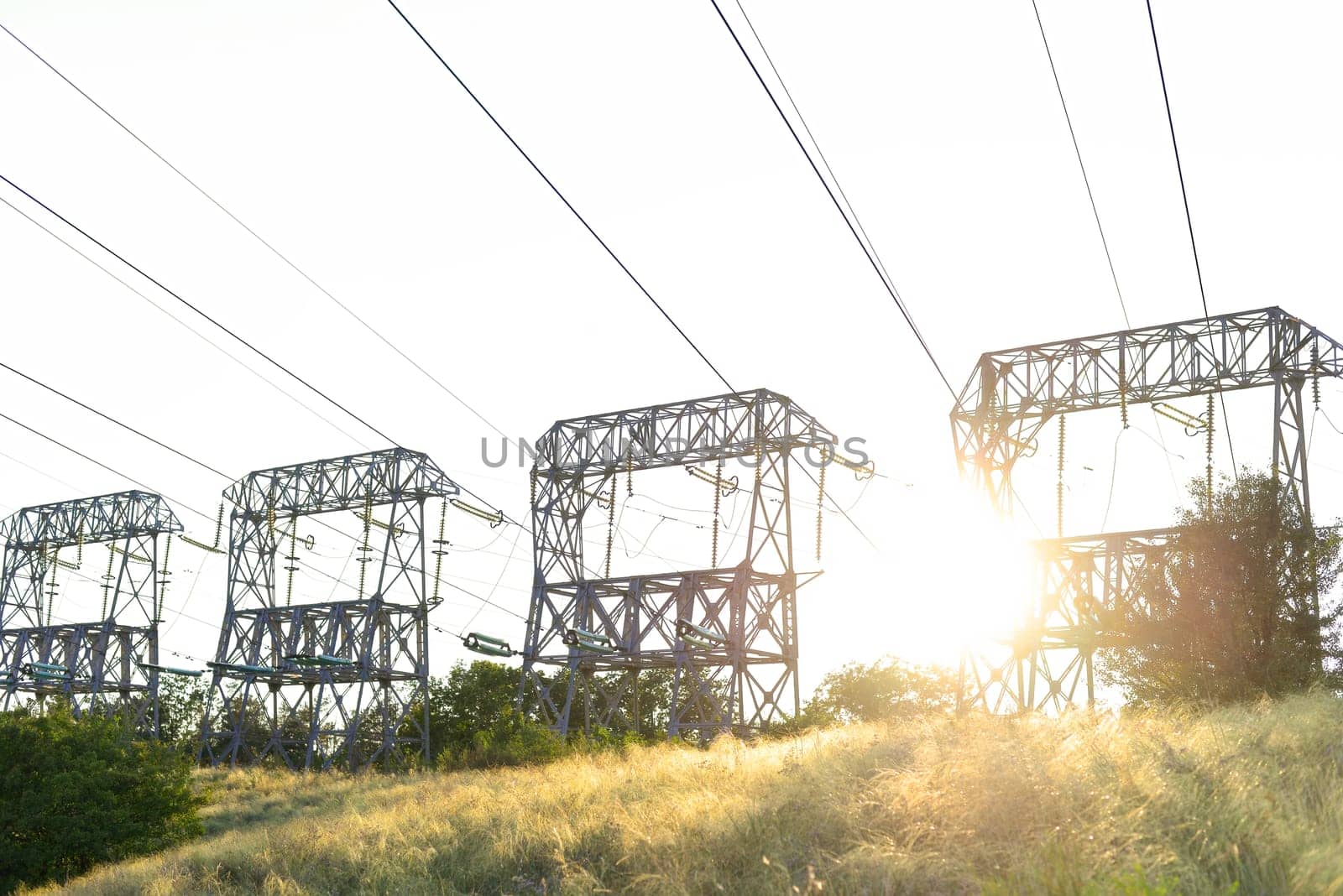 High-voltage power lines at sunset. High voltage electric transmission tower. blackouts