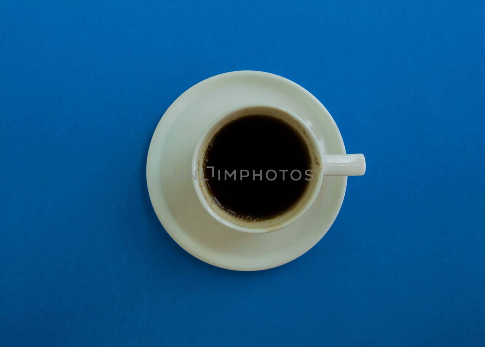 Cup of coffee on a blue background, top view.  by Yuka777