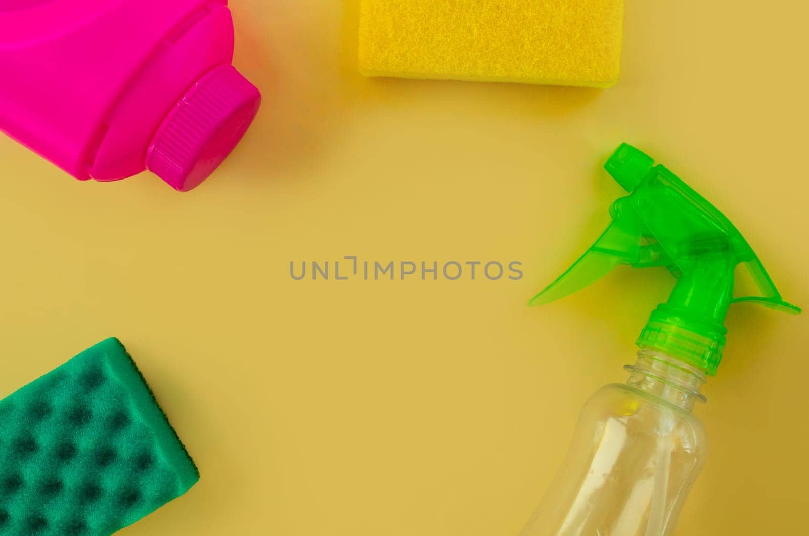 Cleaning. Flat lay Bottles with cleaning product and sponges on a yellow background. Cleaning supplies, top view.