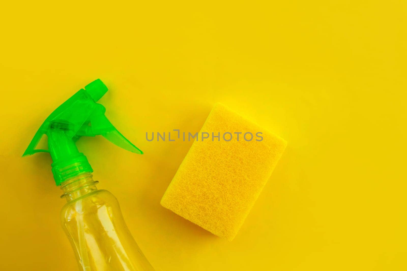 Cleaning. Flat lay Bottle with cleaning product and sponge on yellow background.  by Yuka777