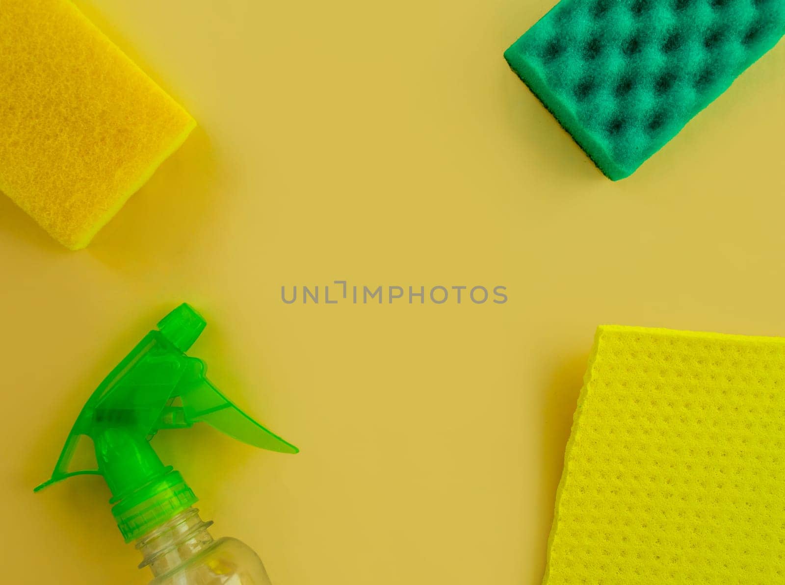 Cleaning. Flat lay Bottle with cleaning product, sponges and rag on a yellow background.  by Yuka777