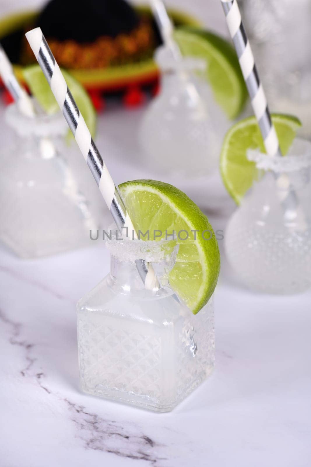 Classic alcoholic cocktail Margarita. Served in mini bottles with salt and lime. An original idea for a buffet event.