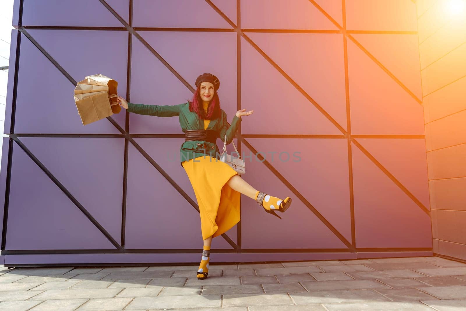 A happy shopaholic girl throws her bags near a shopping center. Have fun shopping on Black Friday. the girl in the store is happy with her purchases, throws packages. Consumer concept