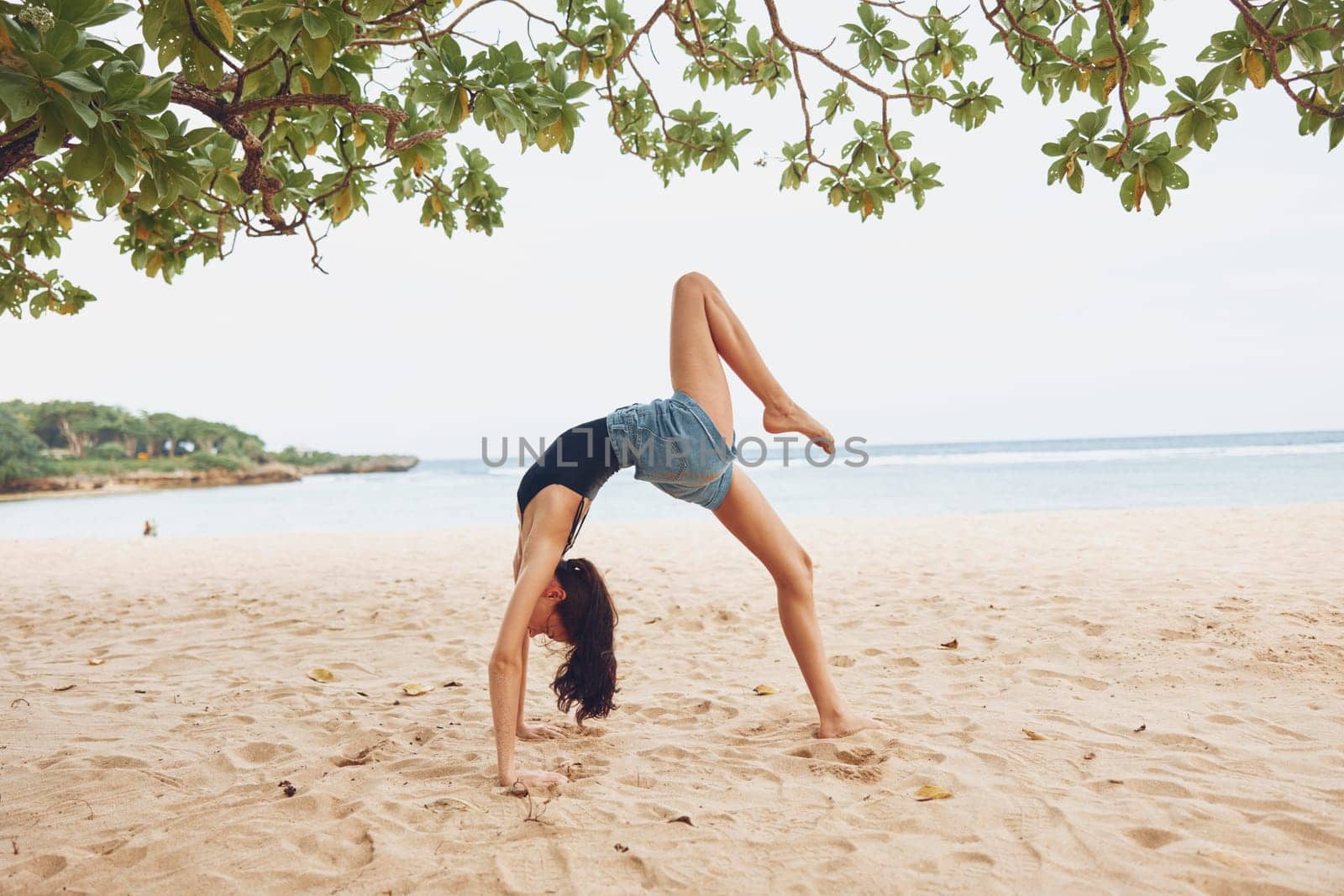 sea woman balance bridge bend stretching gymnastics lifestyle female ocean training calm meditation beach yoga exercise beautiful sport healthy young active