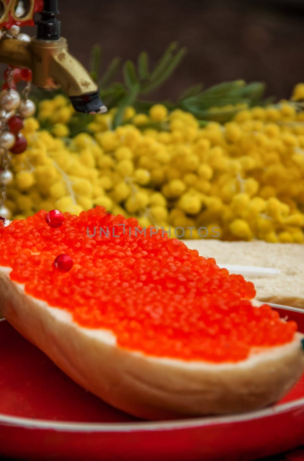 Red caviar is spread on bread with a thick layer. Maslenitsa street fair. Outdoor food