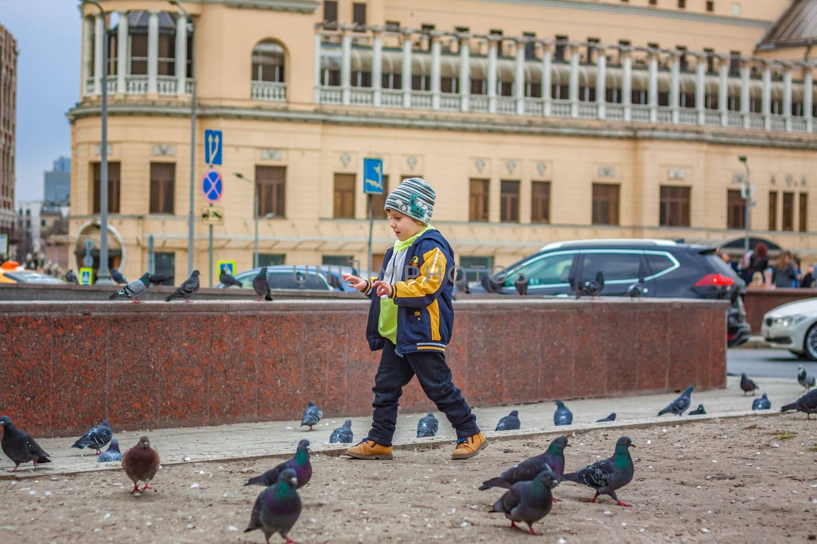 2023-04-09. Moscow, Russia. A boy is hunting and trying to catch street pigeons in Moscow. by Alina_Lebed