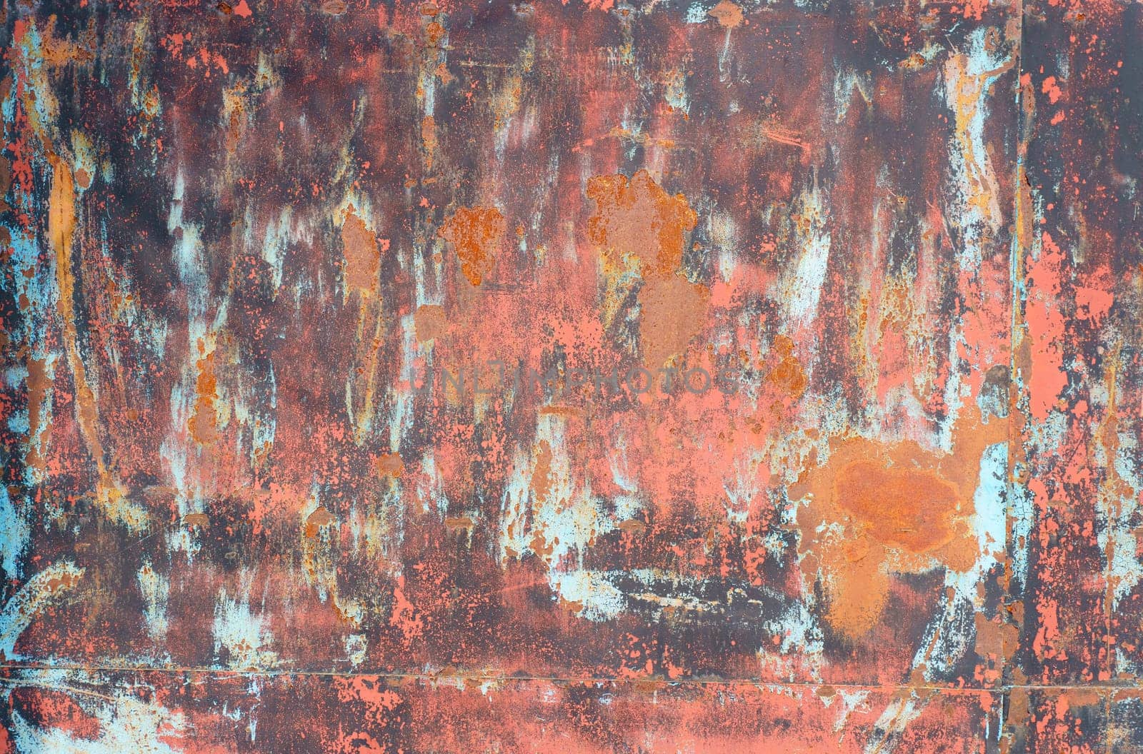 Texture of an old rusty metal sheet with red and gray paint elements. close-up.