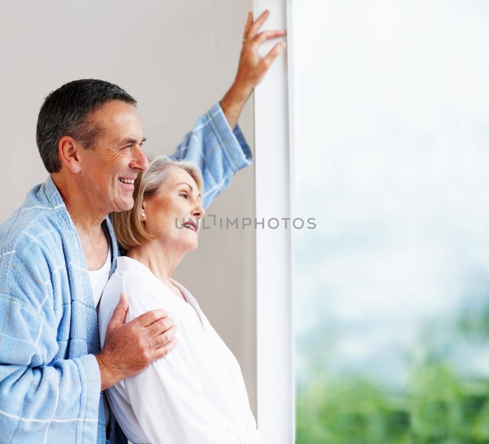 Romantic mature couple looking through window. Portrait of a romantic mature couple looking through window