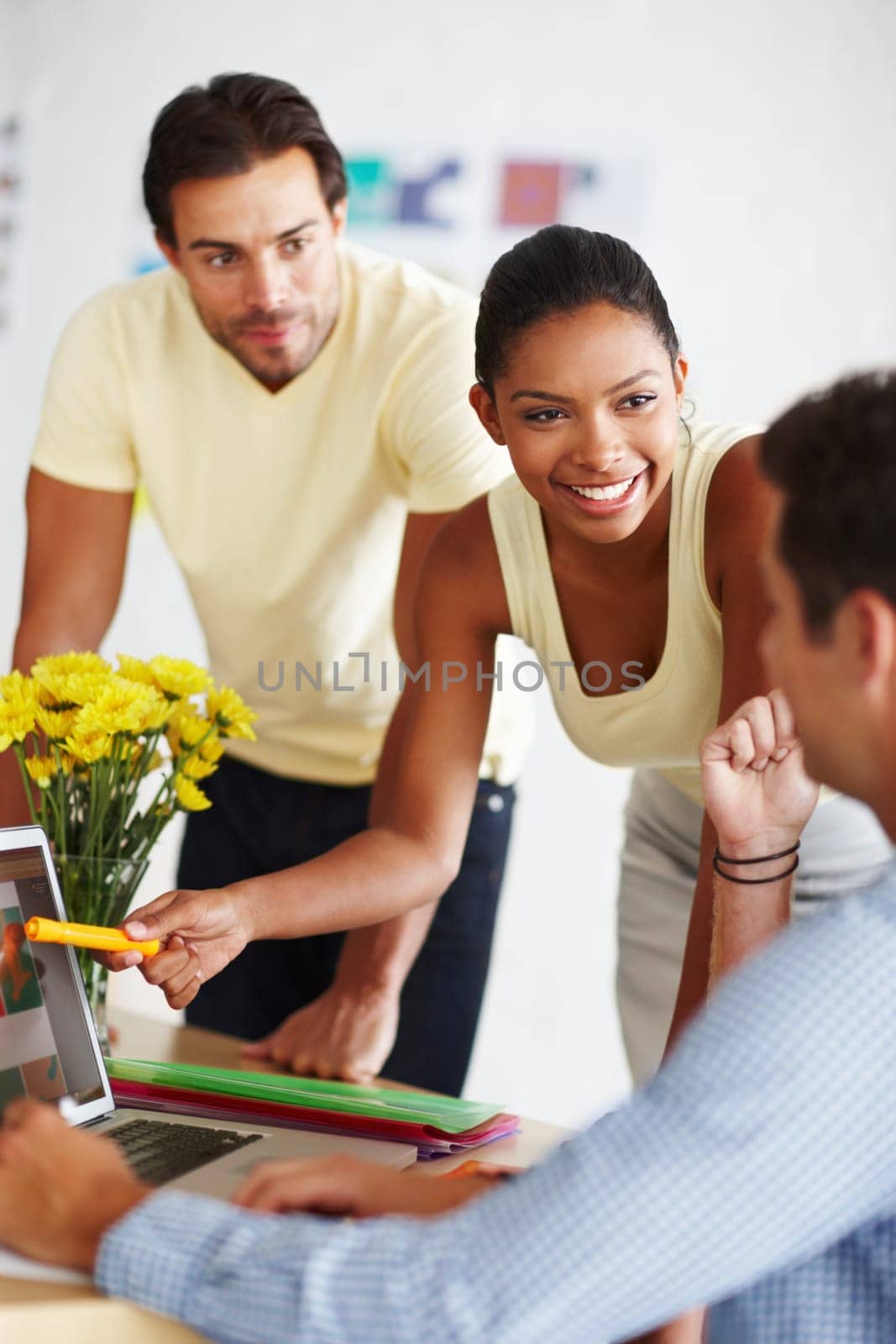 I love this element of the design. a diverse group of designers discussing a project over a laptop