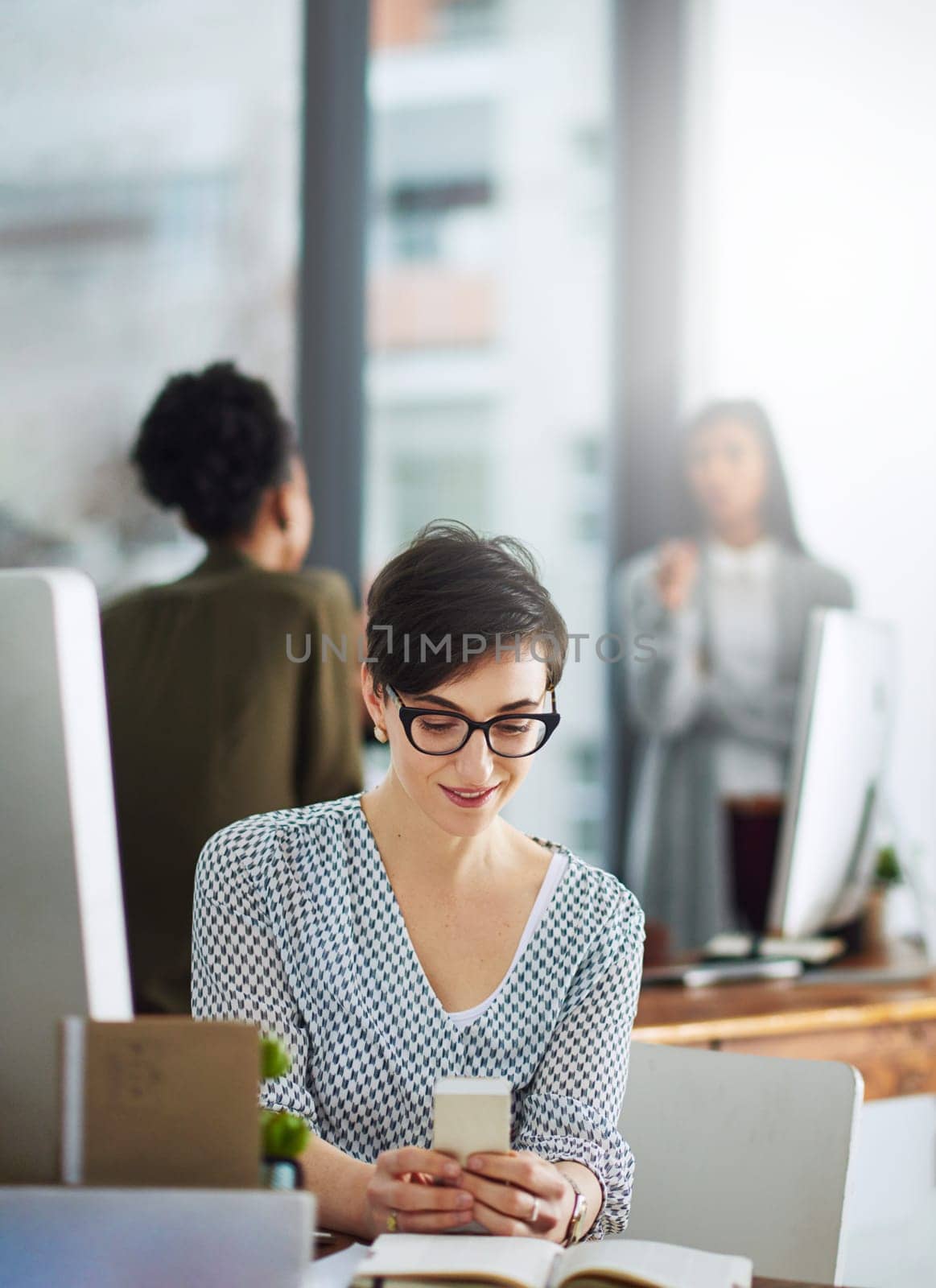 Technology has always been her best tool. a young businesswoman texting on a cellphone in an office