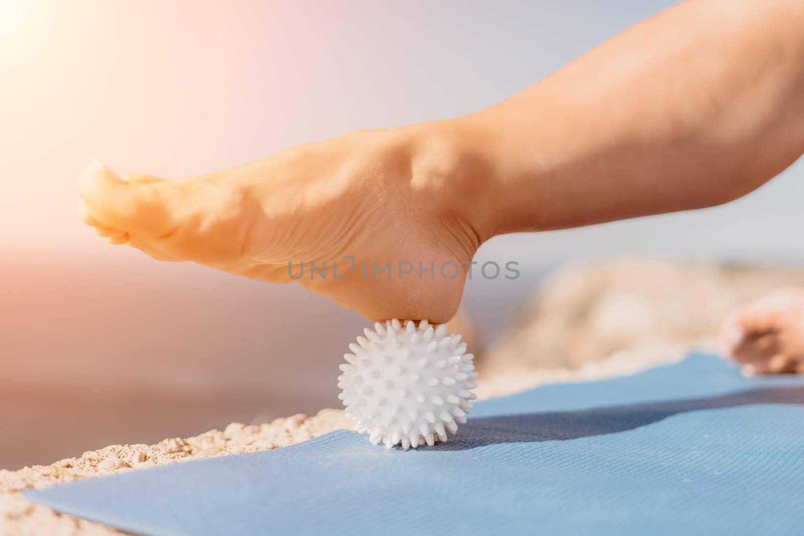 Woman sea pilates. Sporty happy middle aged woman practices pilates on yoga mat by the sea, using massage balls and roller near sea, smiling active female outside, enjoying healthy lifestyle by panophotograph