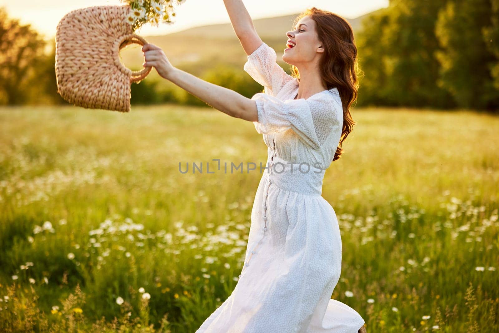 happy woman in a long light dress fool in the field with a wicker basket in her hands. High quality photo