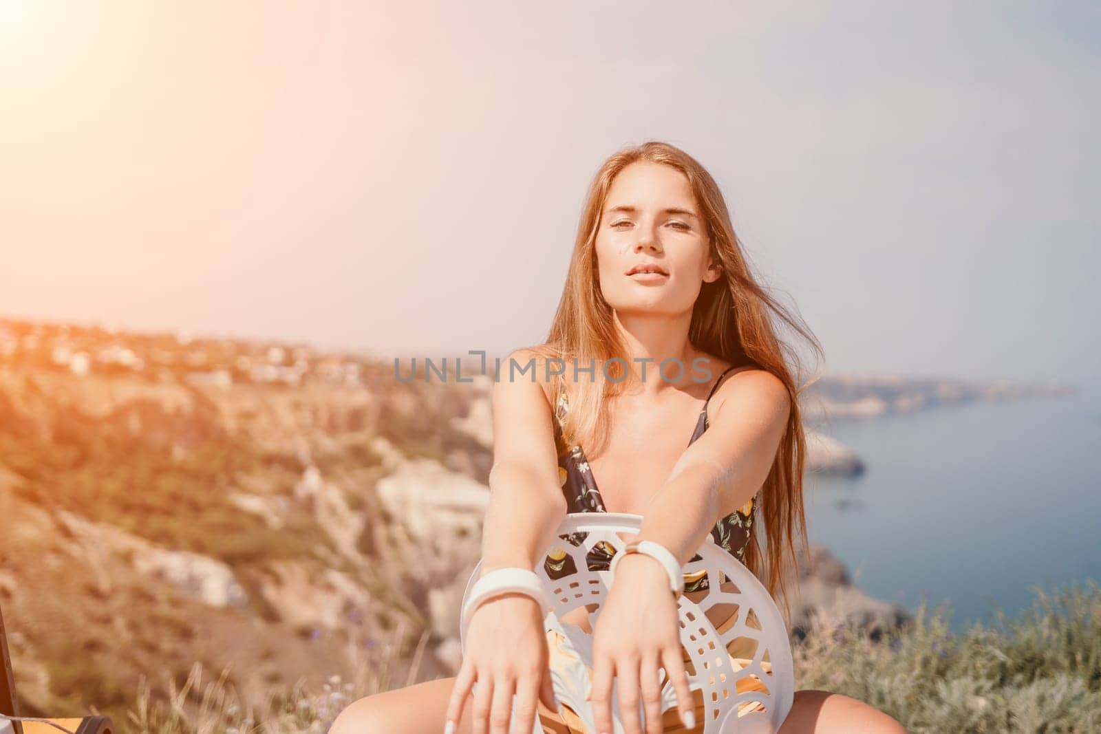 Happy woman portrait in cafe. Boho chic fashion style. Outdoor photo of young happy woman with long hair, sunny weather outdoors sitting in modern cafe