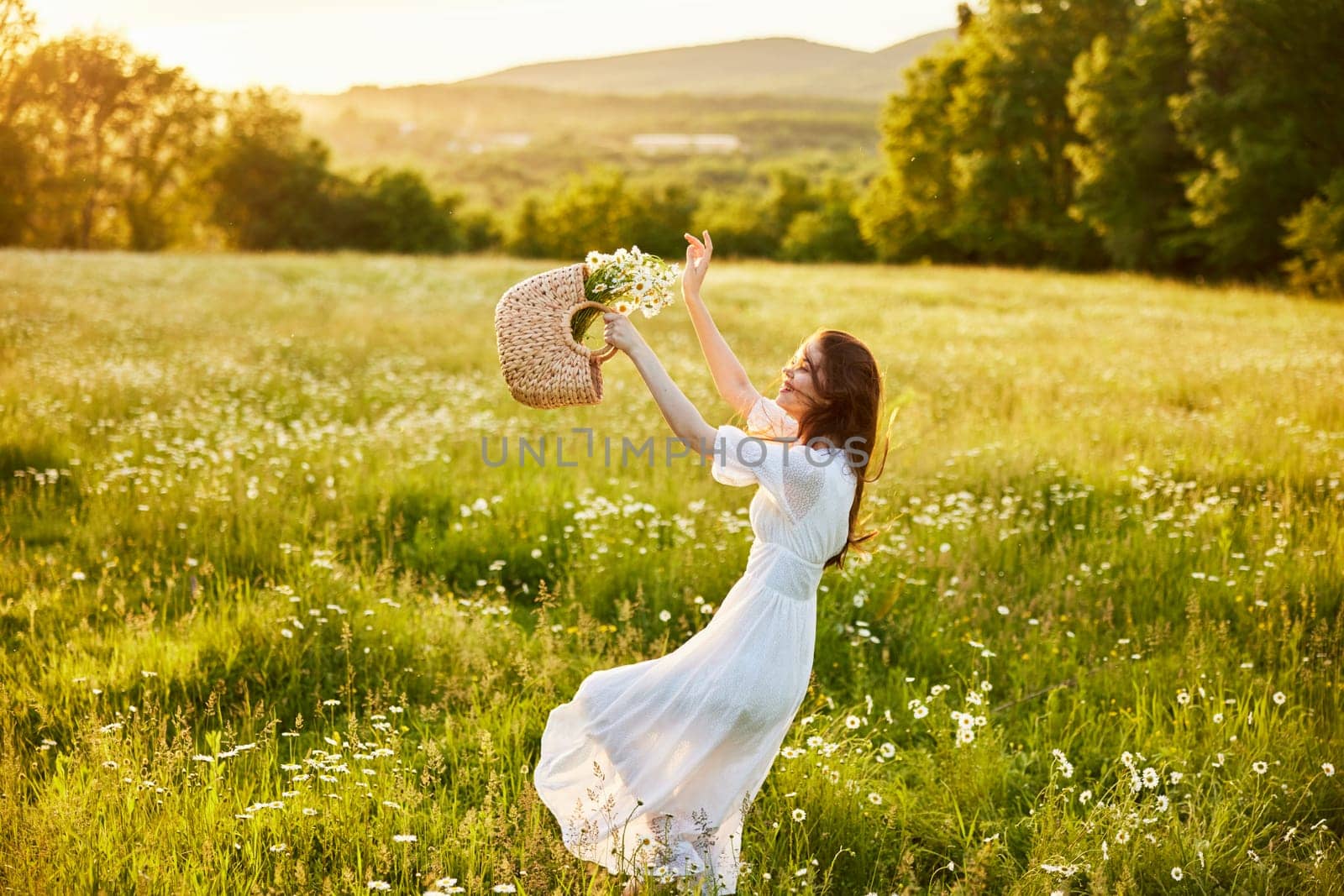happy woman in a long light dress fool in the field with a wicker basket in her hands by Vichizh