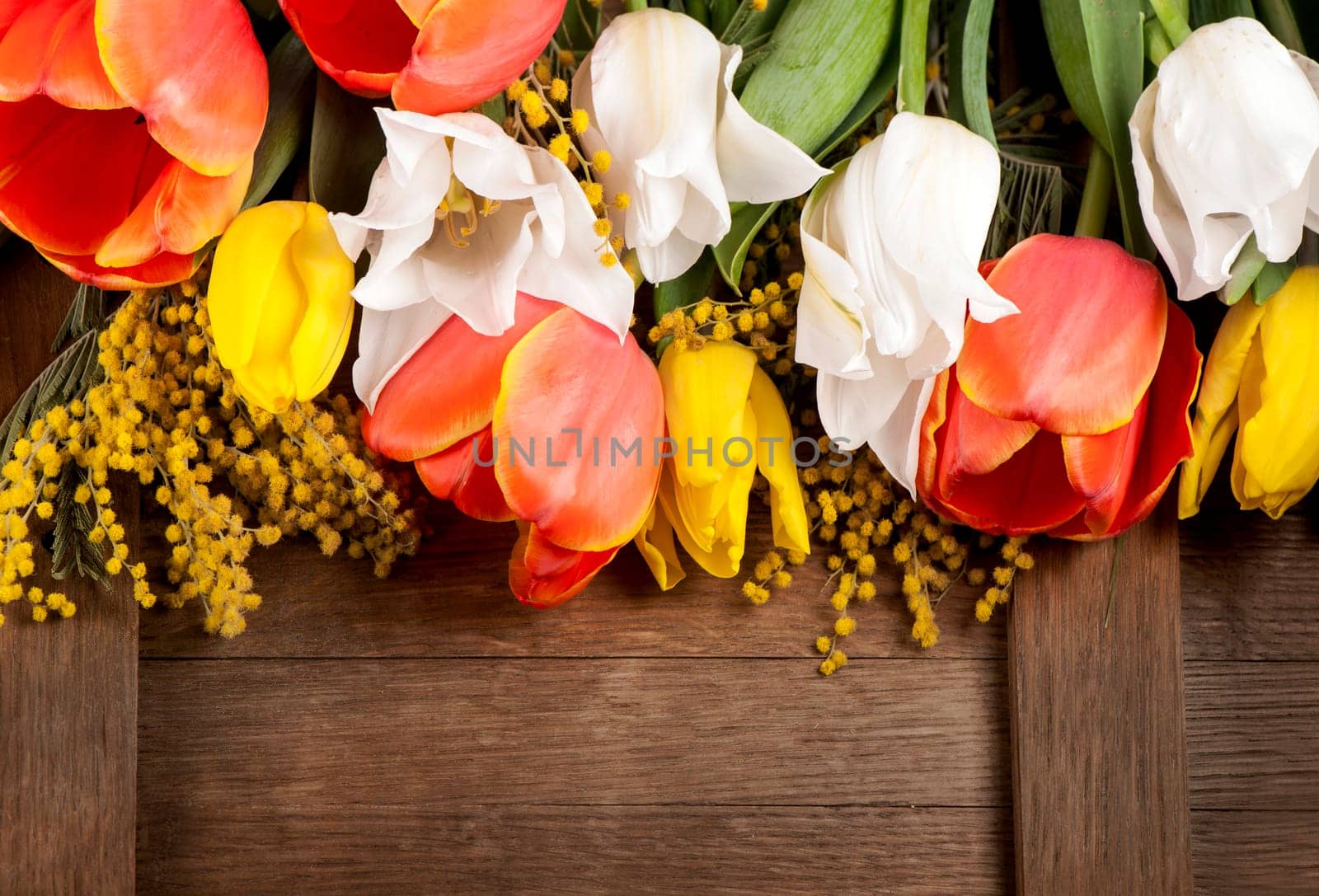 Yellow, red and white spring flowers on wooden background, tulips. by aprilphoto