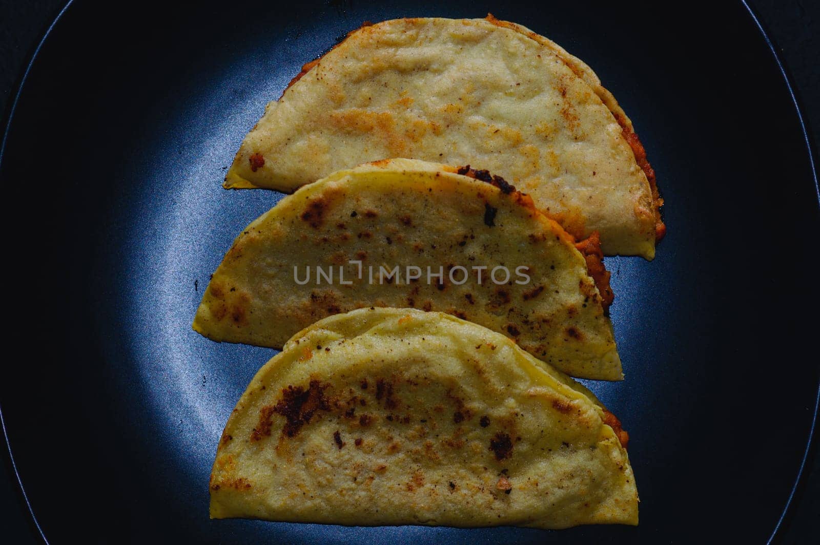 Mashed potato and chorizo fried tacos dorados. Fried mashed potato tacos shot on black background.