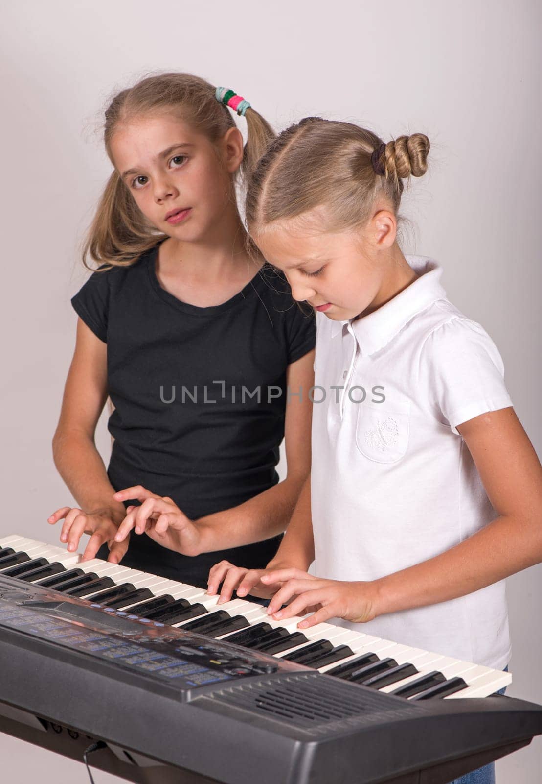Music class in school or at home. Two girls playing piano. Kids play music. Classical education for children. art lesson. Little girl at digital keyboard. Instrument for young student.