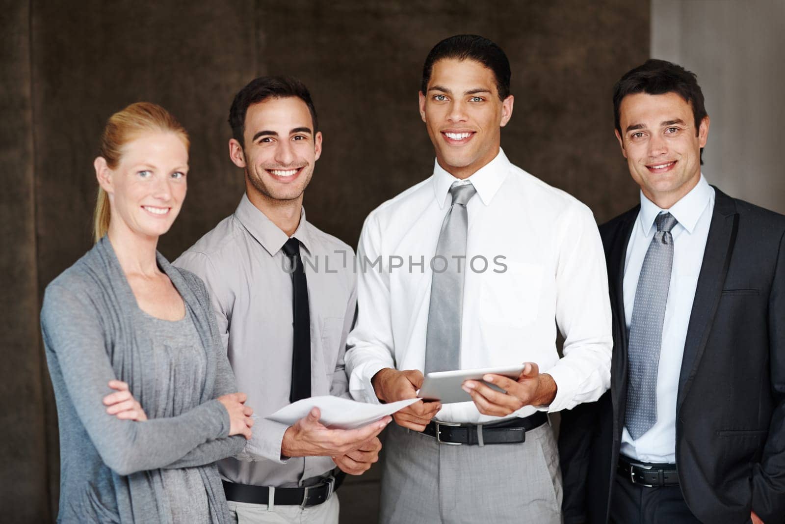 They work well together. Multi-ethnic group of businesspeople talking while using a digital tablet